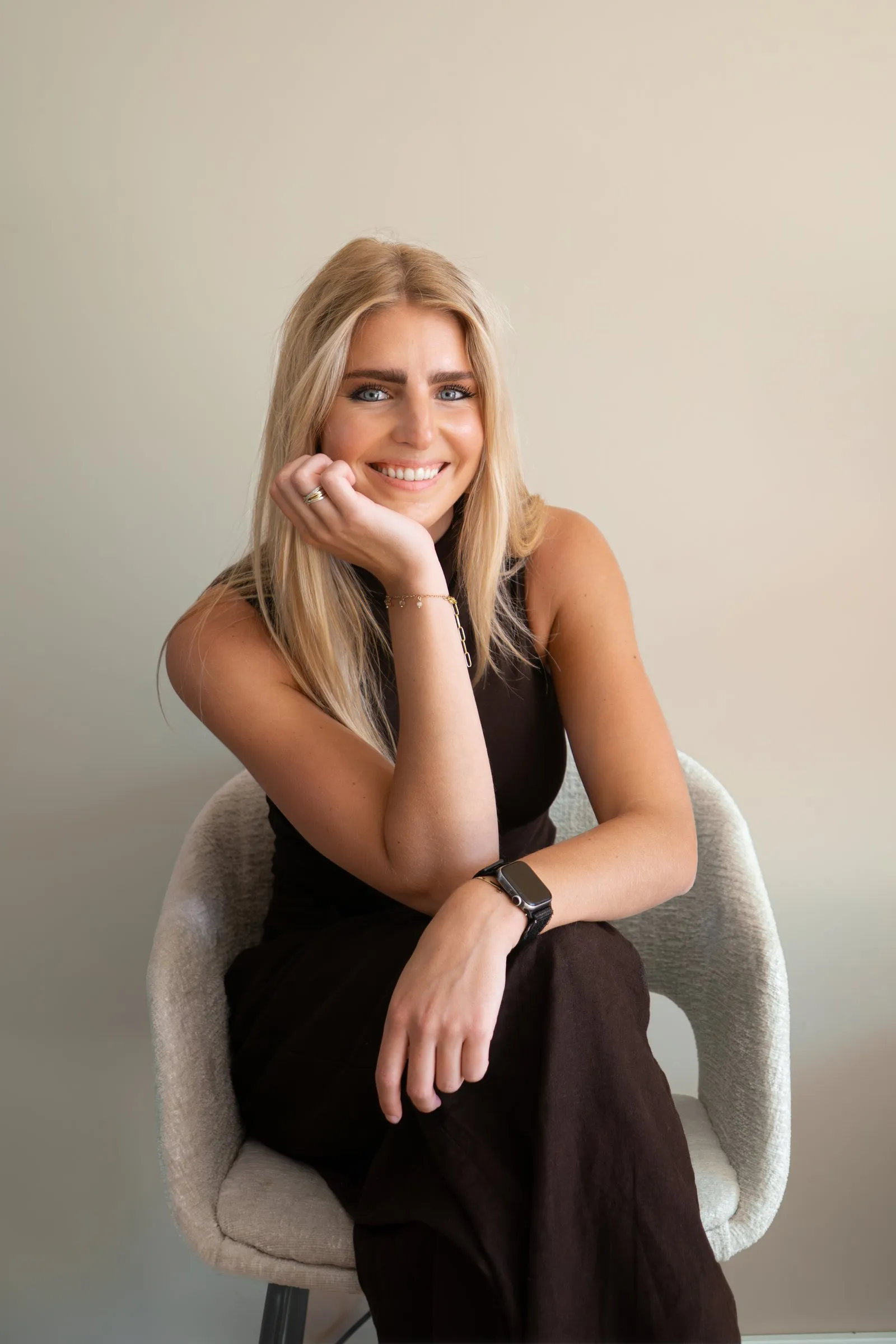 Zittend portret van een vrouw in een lichte stoel, hand langs haar gezicht