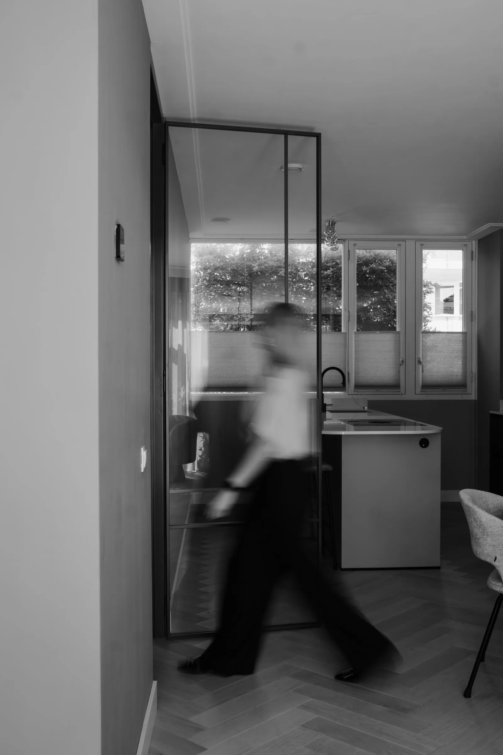 Zwart-witbeeld met bewegingsonscherpte in een hal met visgraatvloer