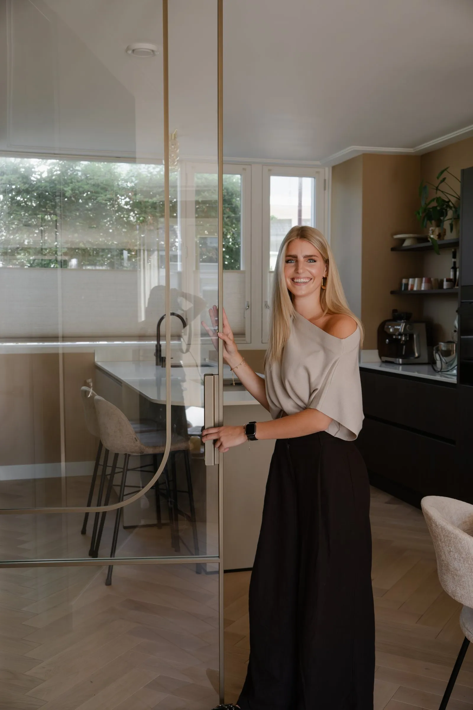 Vrouw in de doorgang van een keuken met glazen wand