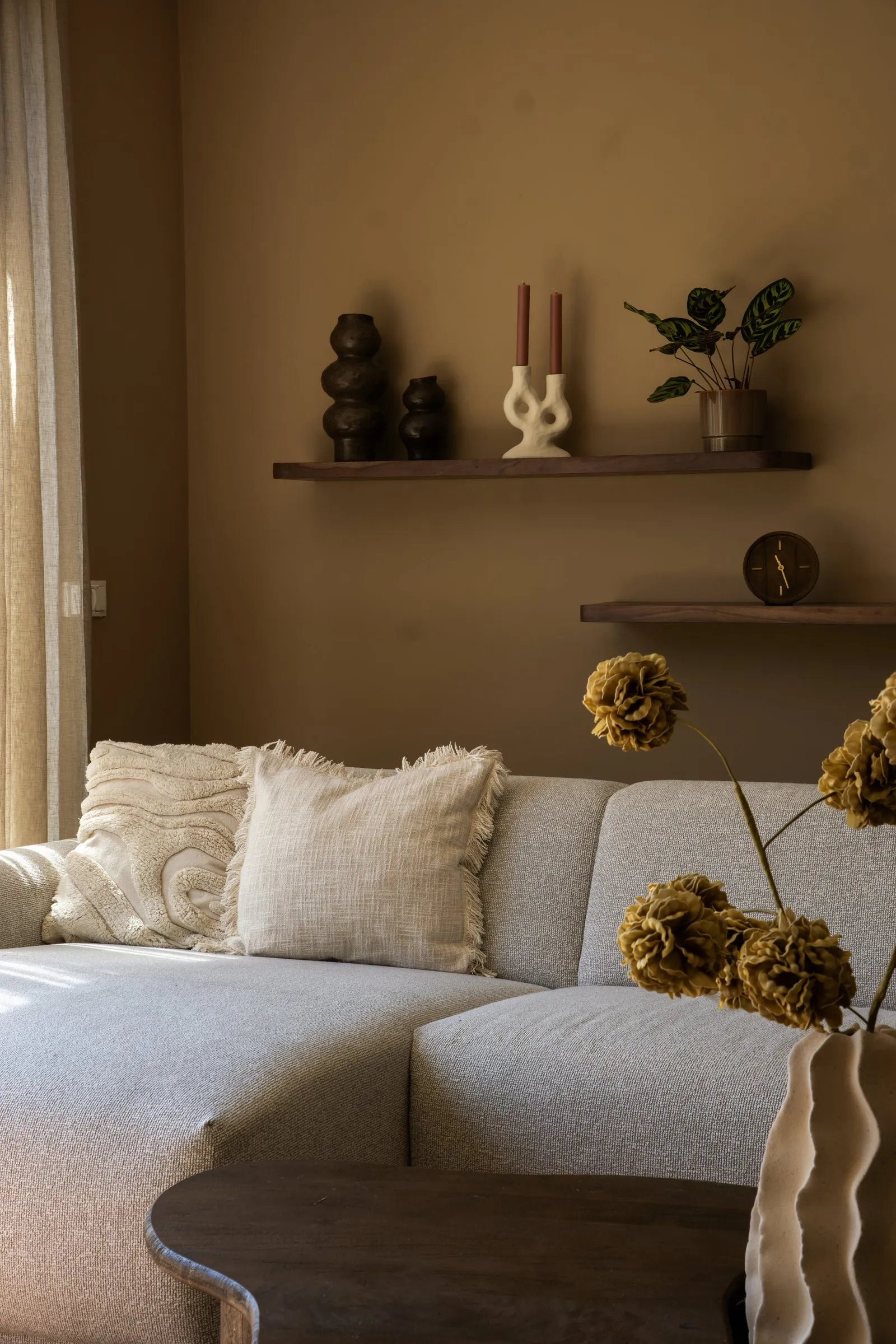 Detail van een bank met wandplank en gedroogde bloemen