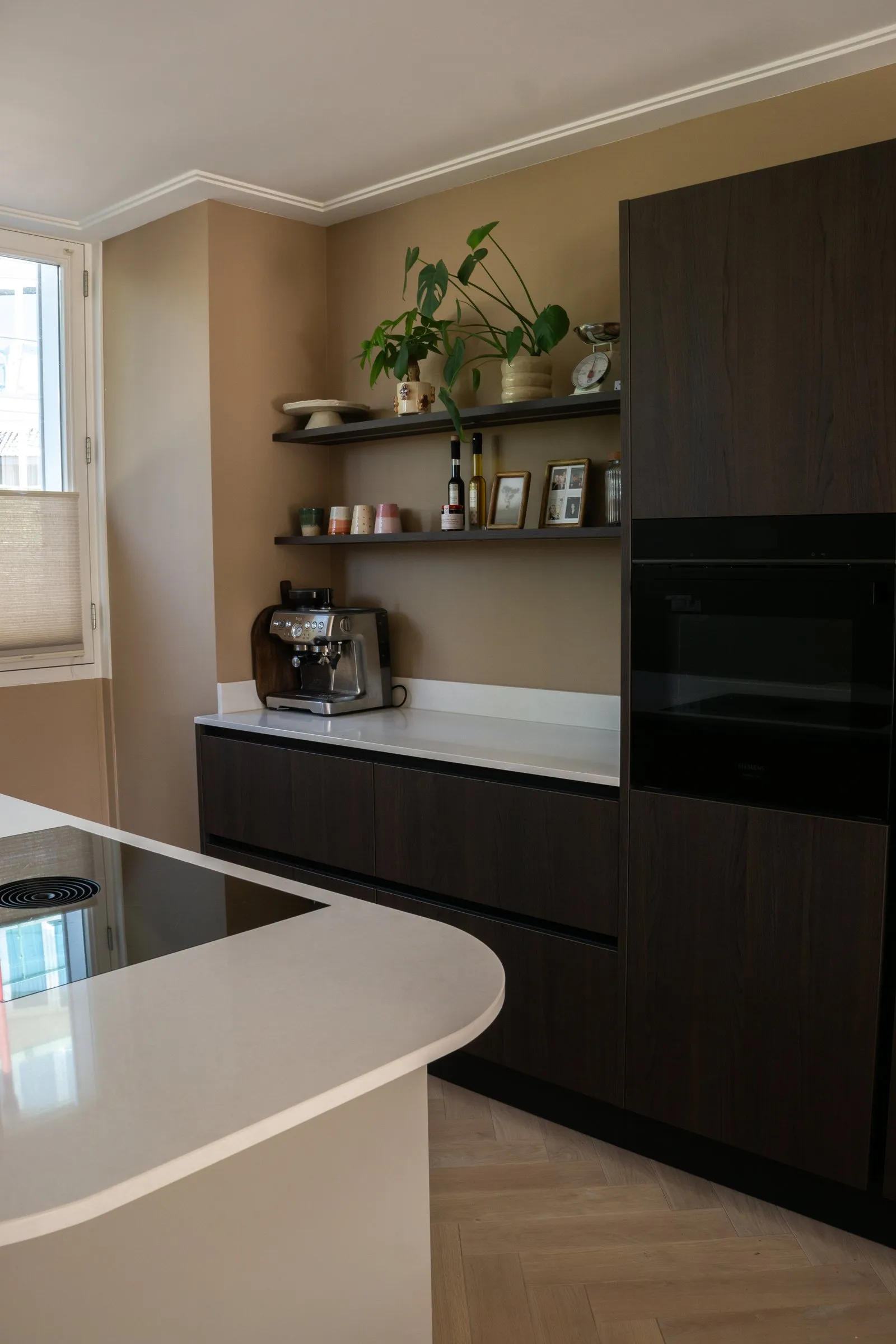 Keuken met donker houten kastenwand en licht kookeiland