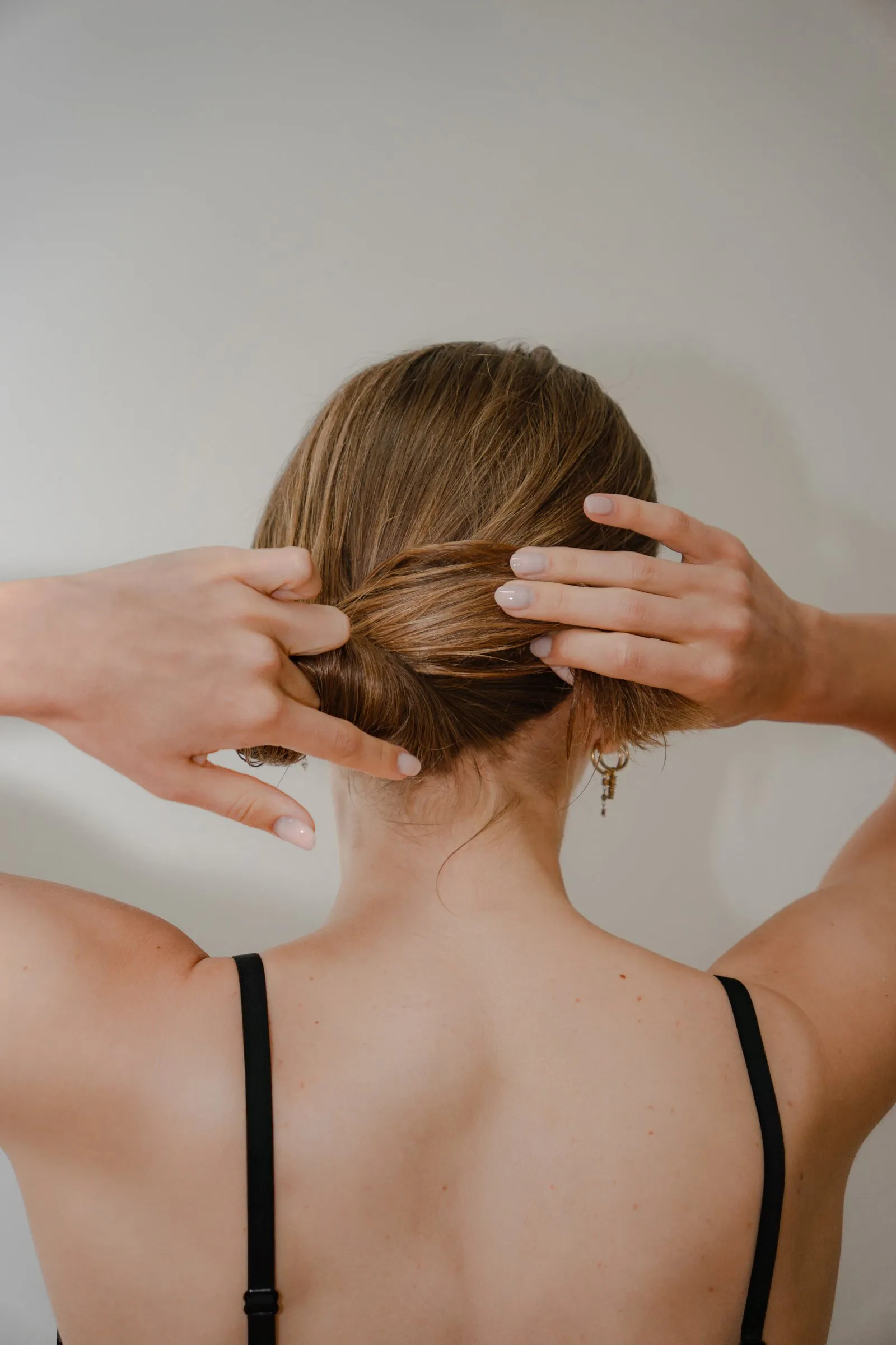 Het haar wordt tot een lage knot gedraaid